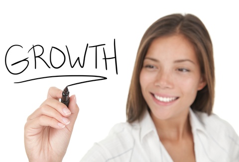 A woman focused her pharmacy business writes the word "growth" with a black marker